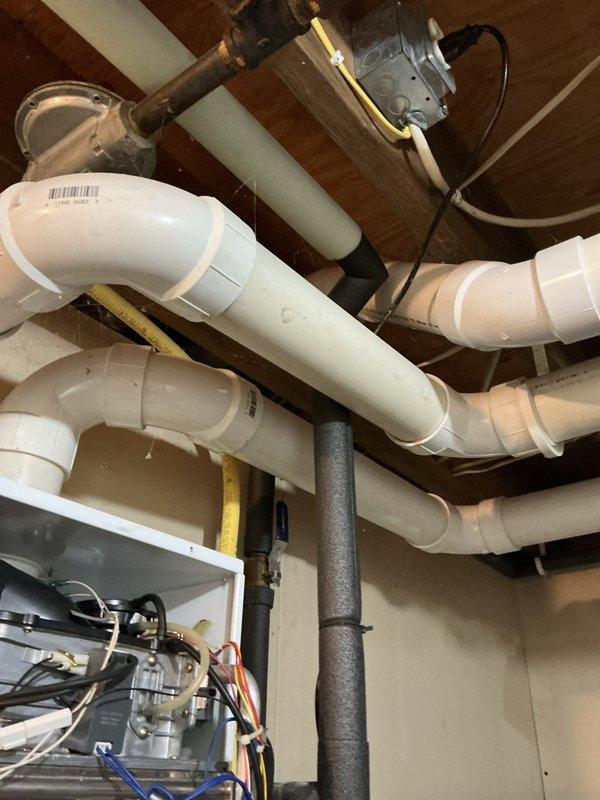Responded to emergency service call for tankless water heater triggering carbon monoxide detector in basement. Upon inspection, identified unglued PVC exhaust joint allowing combustion gases to escape into living space during unit operation. Properly cleaned, primed, and solvent-welded the disconnected exhaust joint to restore safe venting. Tested unit operation and confirmed carbon monoxide detector no longer alarming. Customer reported inadequate hot water duration during extended use, indicating potential capacity or performance issues with existing tankless system requiring further evaluation for replacement options.