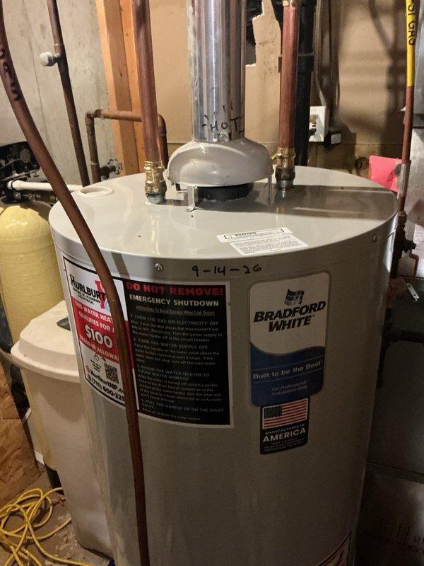 Responded to emergency service call for leaking 21-year-old natural gas 40-gallon water heater. Upon inspection, confirmed active leak from tank indicating internal failure beyond economical repair. Disconnected and drained existing unit, then removed failed water heater from utility area. Installed new Bradford White 40-gallon natural gas water heater to manufacturer specifications. Connected copper supply and distribution lines with proper brass fittings and shut-off valves. Installed code-compliant temperature and pressure relief valve with discharge pipe. Verified all gas connections for proper operation and leak-free performance. Tested unit functionality and confirmed proper ignition, burner operation, and hot water delivery throughout home plumbing system. Removed old water heater from premises and left work area clean.