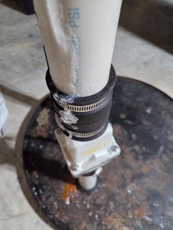 Responded to report of white crystalline substance accumulating on sewage pump discharge piping. Upon inspection, identified improper seal at check valve due to misaligned discharge pipe and deteriorated fernco coupling. Removed defective fernco connector and straightened crooked discharge pipe section to ensure proper alignment with check valve. Installed new fernco coupling and reconstructed affected piping segment to establish secure, leak-free connection. Verified system operation and confirmed elimination of salt-like residue buildup on exterior of discharge line.