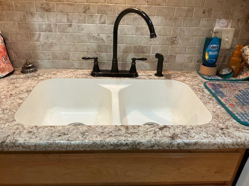 Responded to kitchen sink faucet leak caused by failed internal cartridges. Diagnosed dual-handle Pfister faucet with worn hot and cold cartridges showing mineral buildup and deteriorated seals. Removed both defective cartridges from valve bodies and installed new Pfister replacement cartridges for hot and cold water lines. Tested both handles for proper operation and verified leak was eliminated. System restored to full functionality.