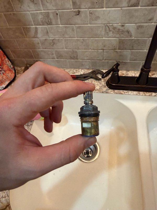 Responded to kitchen sink faucet leak caused by failed internal cartridges. Diagnosed dual-handle Pfister faucet with worn hot and cold cartridges showing mineral buildup and deteriorated seals. Removed both defective cartridges from valve bodies and installed new Pfister replacement cartridges for hot and cold water lines. Tested both handles for proper operation and verified leak was eliminated. System restored to full functionality.
