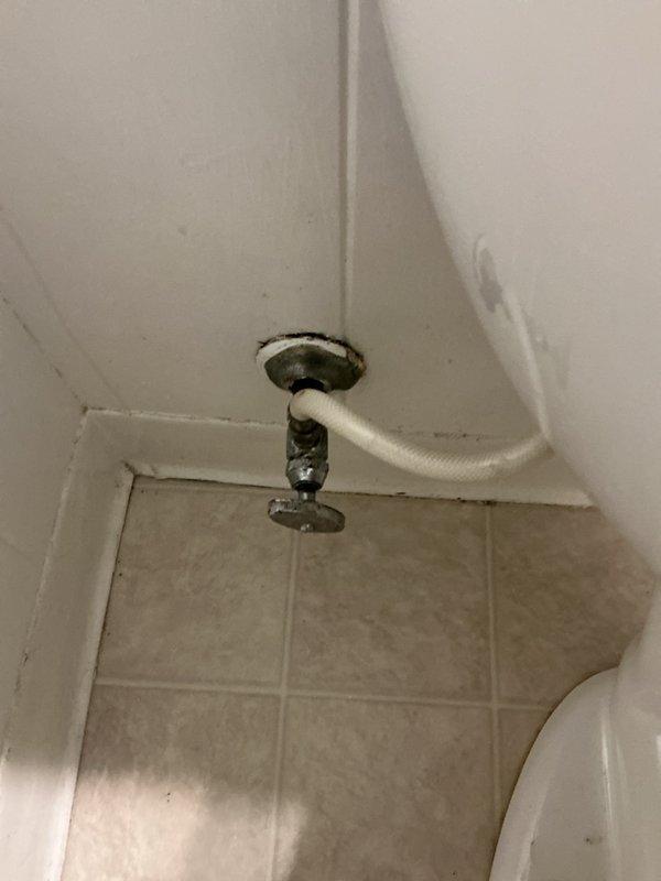 Responded to service call for leaking toilet with failed wax ring seal and inoperative shut-off valve. Upon inspection, identified leaking bolts and gaskets at the base of the toilet fixture. Assessed condition of mounting hardware and sealing components, noting corrosion and deterioration around the flange area. Documented existing conditions and provided estimate for complete toilet replacement due to extent of seal failure and compromised mounting system.