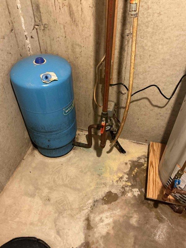 Responded to a leaking 40-gallon LP power vent Bradford White water heater with water discharge from the bottom of the unit. Confirmed the unit was still under warranty coverage and assessed replacement options, noting that 50-gallon units were available on the service vehicle. Provided technical assistance with the water heater replacement process, including disconnection of copper supply lines, removal of the failed unit from wooden blocking supports, and preparation of the installation area in the basement utility space where the pressure tank and related plumbing infrastructure are located.