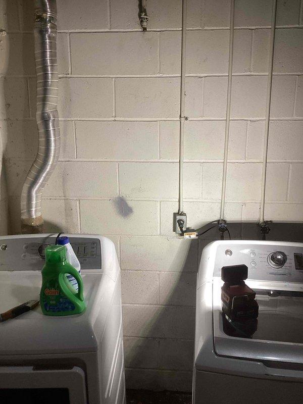 Responded to service call for gas dryer hookup in residential basement laundry area. Upon inspection, determined that contrary to initial report, no existing gas line was present to supply the dryer location. Additionally, identified that the current gas valve installation does not meet current code requirements and would need to be brought up to compliance standards. Documented existing conditions with photographs showing laundry appliances, utility room configuration, and mechanical equipment. Provided detailed estimate to property owner outlining scope of work required to install proper gas line and code-compliant valve assembly to enable safe dryer connection.