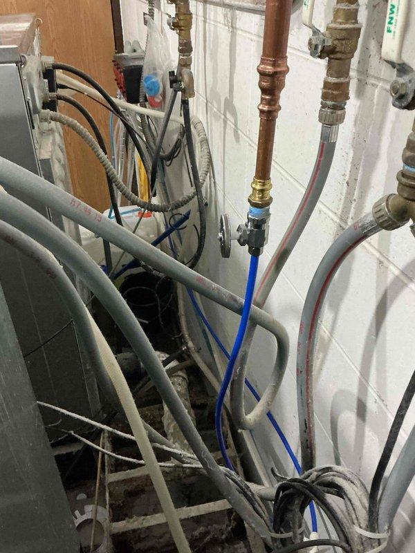 Installed state-approved ASSE 1013 reduced pressure principle backflow preventer to address high hazard cross-connection concerns from laundry detergents and bleach concentrates connected to the potable water system. The RPZ assembly was required to pass cross-connection control inspection and includes brass valves, copper piping, Y-strainer, and test cocks mounted on utility room wall. Device has been registered and will require annual testing by an approved cross-connection control specialist to maintain compliance.