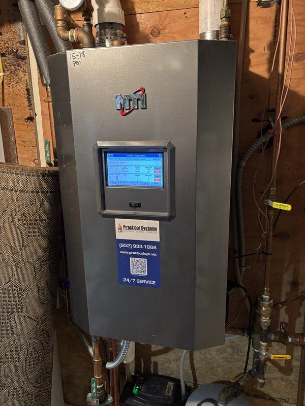 Responded to no hot water complaint on recently installed indirect water heater system. Upon arrival, met with property manager who provided access to boiler and indirect water heater location. Found both boiler and indirect water heater operating properly with water temperature at 140°F. Adjusted mixing valve downward to safe operating range of 120-130°F to prevent scalding hazard. Determined that alarm system had previously indicated a leak condition and was reset by maintenance personnel, which likely triggered a boiler lockout preventing the indirect water heater from heating. Verified all components functioning correctly with no active faults or leaks present. Confirmed proper water temperature at fixtures and left heating system in normal operation.