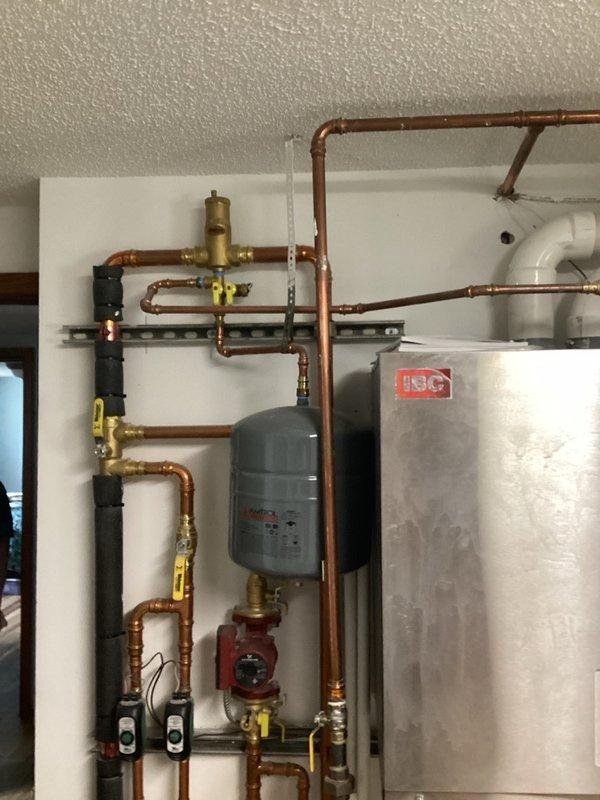 Responded to service call for boiler system with no hot water and failed display. Upon arrival, diagnosed failed control board preventing system operation. Unable to complete scheduled maintenance tune-up due to non-operational control board. Ordered replacement control board for hydronic heating system. Documented existing installation including expansion tank, circulator pump, copper piping network with brass fittings, and stainless steel storage tank. System currently inoperable pending replacement board installation to restore hot water functionality and complete annual maintenance tune-up.