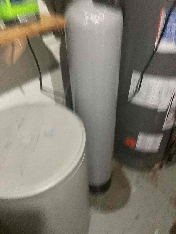 Responded to a water treatment system emergency involving a constant leak that required shutting off the main water supply. Upon inspection, identified a fiberglass tank failure on a water conditioner unit installed in December 2023, with active leaking occurring at the top of the conditioner tank. Documented the failed fiberglass tank condition with photographs for warranty and replacement purposes.