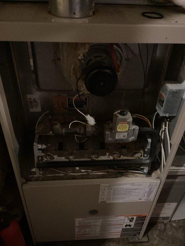 Responded to no heat call on 21-year-old LP furnace. Upon arrival, found unit non-operational with pilot light unable to ignite. Conducted thorough diagnostic inspection of furnace and surrounding basement area. Discovered significant water accumulation in basement due to drain backup, potentially related to water heater condition. Inspected furnace components and identified seized inducer motor as root cause of heating failure. Manually rotated inducer motor shaft, which temporarily freed the motor and allowed it to activate, confirming electrical functionality. However, motor exhibited severe mechanical degradation and binding consistent with age and wear. Given the critical role of the inducer motor in establishing proper draft and combustion airflow, determined that replacement is necessary for reliable winter operation. Assessed overall furnace condition and noted general deterioration consistent with 21 years of service life. Documented findings with photographic evidence showing