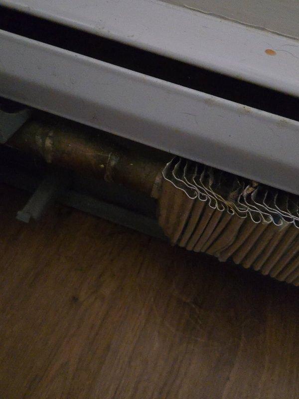 Responded to water leak complaint at multi-unit property with shared boiler system serving six condos. Inspected baseboard heating system and identified active water leak at baseboard heater unit in front room. Documented conditions with photos showing aged finned heat exchanger components and boiler control panel with on/off switch. Customer declined to have shared boiler system activated at this time. Provided parts estimate for repair, noting that boiler equipment is HOA-owned and serves multiple units requiring coordination with property management for resolution.