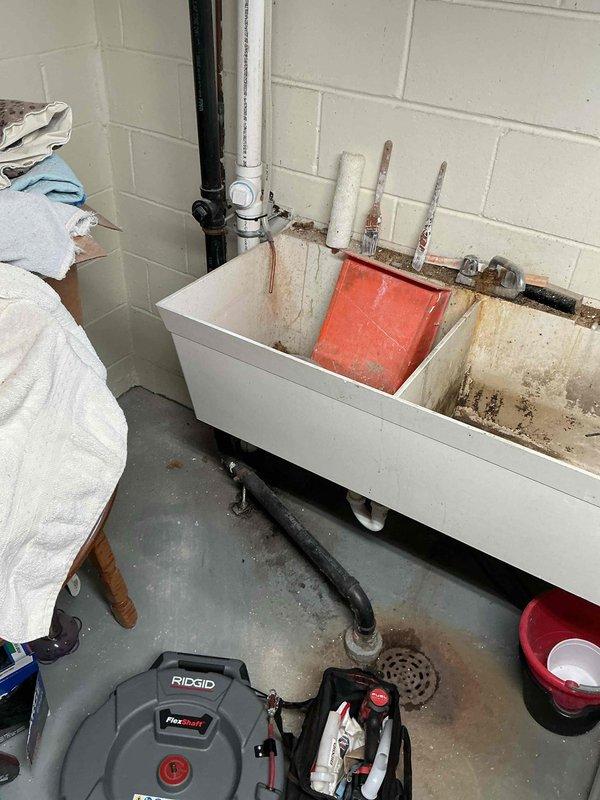 Responded to a kitchen/laundry drain system experiencing water backup after recent kitchen drain replacement. Upon initial diagnostic inspection, camera scoping revealed standing water at the point where the drain line transitions underground, indicating a blockage in the main line.

Performed mechanical cable cleaning of the drain line to its full accessible length, successfully removing a significant accumulation of lint and debris causing the obstruction. Following the cable work, conducted a complete camera inspection from the drain opening through to the mainline connection to verify full clearance and proper flow throughout the system.

Completed comprehensive flow testing at the laundry tub by filling and draining multiple cycles to confirm the drain system was operating at full capacity without any backup into the floor drain. All water discharged freely through the system, confirming successful restoration of proper drainage function.