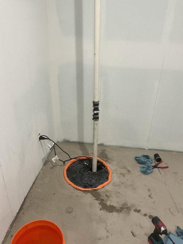 Responded to emergency service call for smoking sump pump in owner-occupied residential property. Upon inspection, determined complete sump pump failure, likely caused by obstruction at the drainfield preventing proper drainage. Removed failed pump unit from sump pit and cleared basin of debris. Installed new sump pump assembly with appropriate discharge piping, secured vertical PVC discharge line to wall corner with mounting straps, and verified proper sealing of floor penetration with gasket ring. Tested new pump operation to confirm proper cycling and drainage functionality. Customer approved replacement solution and installation was completed successfully.