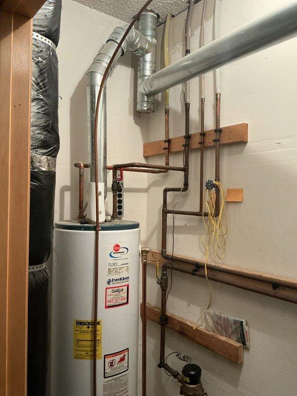 Responded to emergency call for massive leak under kitchen sink. Upon inspection, identified defective fixture stop as source of leak, which had caused significant water damage to flooring and utility room walls. Replaced faulty fixture stop to stop active leak and prevent further damage. Also provided estimate for water heater replacement as requested by homeowner. Documented existing water damage to laminate flooring and utility room baseboards with photographs for insurance purposes.