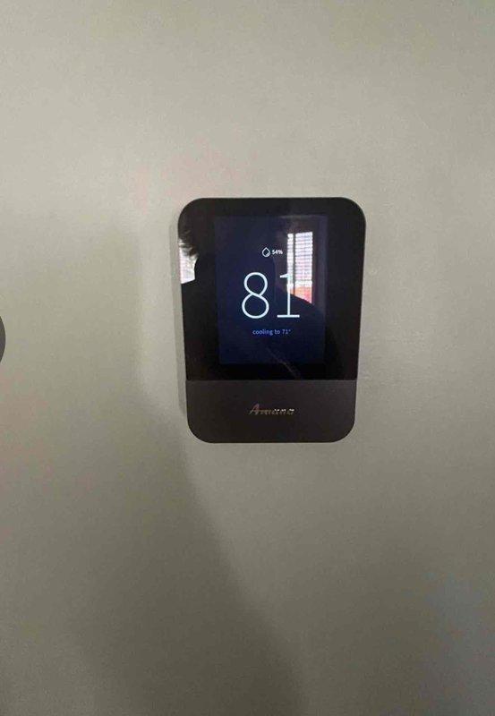 Responded to service call for malfunctioning thermostat experiencing erratic behavior and display glitching. Upon arrival, diagnosed faulty Amana digital thermostat that was previously installed and determined unit was covered under warranty. Removed defective thermostat from wall mount and installed replacement unit. Verified new thermostat powered on correctly, display functioning properly, and system communication established. Tested cooling cycle operation and confirmed accurate temperature readings and proper system response to setpoint adjustments.