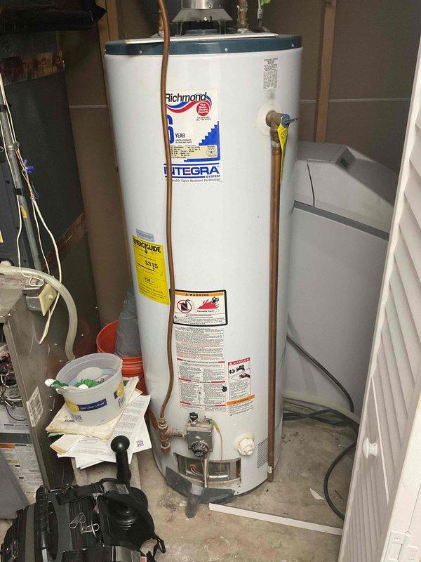 Completed comprehensive plumbing inspection of residential property's mechanical systems located in basement utility area. Inspected and documented Richmond Integra water heater with visible copper piping, pressure relief valve, and proper labeling including energy guide information, as well as adjacent water softener/filtration system with digital control panel. All equipment photographed and assessed for proper installation, connections, and operational status as part of recurring maintenance inspection program.