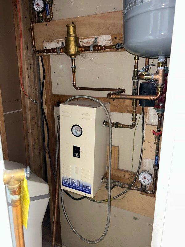 Completed comprehensive furnace and boiler tune-up maintenance visit in response to reported cricket-like noises from the boiler system. Performed full furnace inspection including thermostat operation, air filter condition, blower assembly, burner/heat exchanger compartment, inducer operation, ignition system, flame sensor, safety controls, electrical components, condensate drain, and temperature rise measurements. Cleaned flame sensor, cleared condensate drain line of debris, and cleared both pressure tube and condensation tube to ensure proper drainage and system operation. Inspected wall-mounted hydronic boiler system with Mini brand unit, verified pressure gauge readings, and documented system configuration including expansion tank, air separator, and copper piping network. All temperature and operational readings fell within normal operating range with no mechanical deficiencies or safety issues identified at this time. Advised customer to maintain monthly air filter replacement 