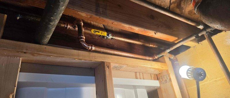 Replaced a failing water control valve up to 1" in the basement plumbing system. Installed a new ball, gate, swing, spring, or check valve to restore proper water flow control through the main water line. The copper piping system was accessed at the ceiling joists, and the new valve with yellow handle was properly integrated into the existing plumbing configuration to ensure reliable shut-off capability.