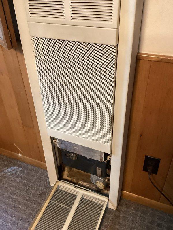 Responded to service call for non-operational gas wall furnace with malfunctioning control knob and pilot light that had been off since early summer. Performed diagnostic inspection by removing lower access panel to assess internal components, which revealed accumulated dust and debris within the unit. Documented existing conditions and provided replacement estimate as requested, as the control system requires replacement to restore proper functionality.