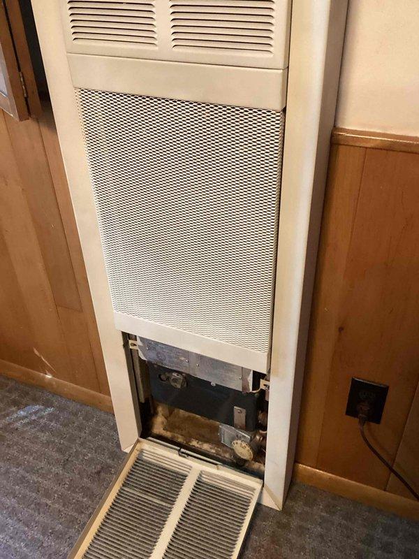 Responded to service call for non-operational gas wall furnace with malfunctioning control knob and pilot light that had been off since early summer. Performed diagnostic inspection by removing lower access panel to assess internal components, which revealed accumulated dust and debris within the unit. Documented existing conditions and provided replacement estimate as requested, as the control system requires replacement to restore proper functionality.