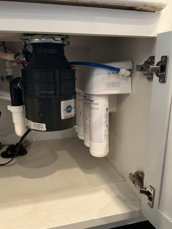 Responded to service call for reverse osmosis system producing insufficient water output (approximately 100 ounces per day). Upon inspection, discovered storage tank pressure was low at 6 PSI and filters were approaching replacement interval. Adjusted storage tank air pressure to proper operating level of 9 PSI using calibrated pressure gauge. Replaced three filtration cartridges in the multi-stage RO system to restore proper flow rates and water production capacity. System tested and returned to normal operation.