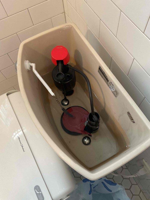 Diagnosed failing flush valve in toilet tank and sold customer on replacement of standard diameter flush valve and gaskets. Documented existing conditions showing worn flapper valve and fill valve assembly requiring replacement. Repair sold and awaiting parts arrival from shop to complete installation of new standard flush valve components.