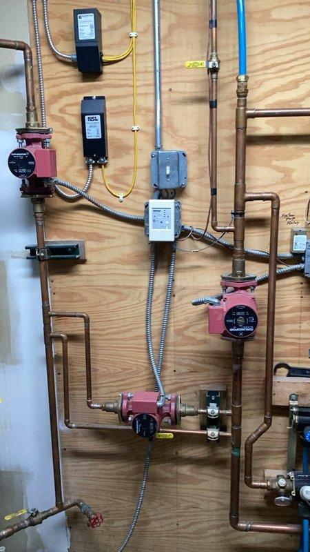 Completed plumbing inspection and multiple repairs. Diagnosed and replaced defective Kohler cartridge in lower bathroom shower valve due to malfunction. Installed customer-supplied bathroom sink with new faucet and handle assembly to replace broken fixture. Inspected hydronic heating system with multiple zone circulators, copper distribution piping, and associated controls—all components found operating within normal parameters. Documented existing plumbing infrastructure including three-zone circulator pump configuration, gas line routing, and system control panels. All repairs tested and verified for proper operation with no leaks detected.