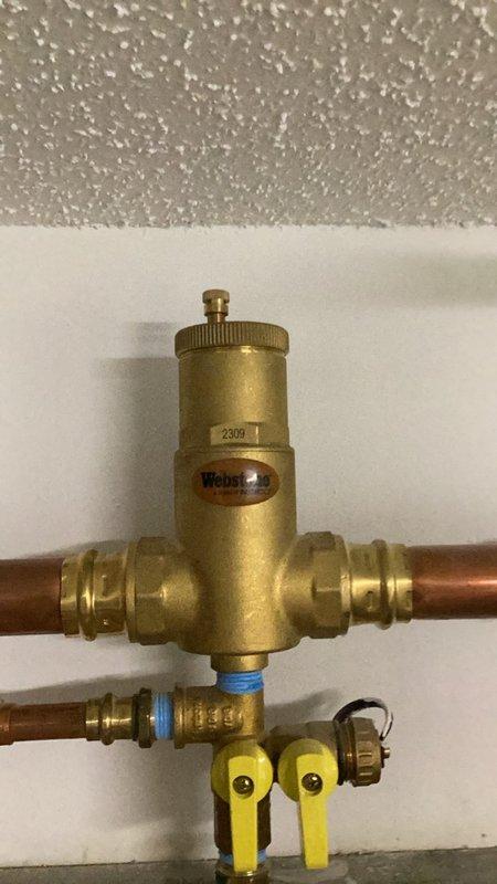 Responded to no hot water complaint and found boiler controller board failed with blank display screen preventing system operation. Replaced defective V-15 control board and performed complete system reset. Programmed all heating zones and domestic hot water settings, then cycled system to verify proper operation. Adjusted and set gas pressures and combustion parameters to manufacturer specifications. Purged air from all heating zones and verified auto-fill operation and settings. Secured loose wiring and thermostat wires that were left hanging from previous remodeling work. Identified damaged air relief valve caused by prior system freeze event and ordered replacement cartridge for future installation. System restored to normal operation with all zones functioning properly.