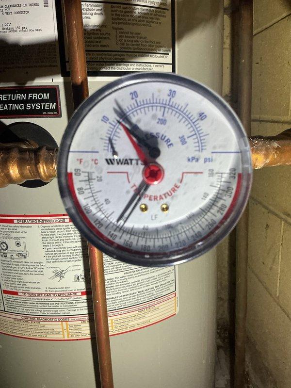Responded to service call for water heater leaking from bottom. Upon inspection, determined the discharge valve was the source of the leak, not the tank itself. The combi unit was running excessively hot, and the recirculation pump was found unplugged. Intermittent leaking observed - unit not actively leaking during service but evidence of significant water discharge when failure occurs. Due to age of equipment, condition of corroded valve assembly, overheating issues, and mixing valve concerns, recommended full system replacement rather than repair.