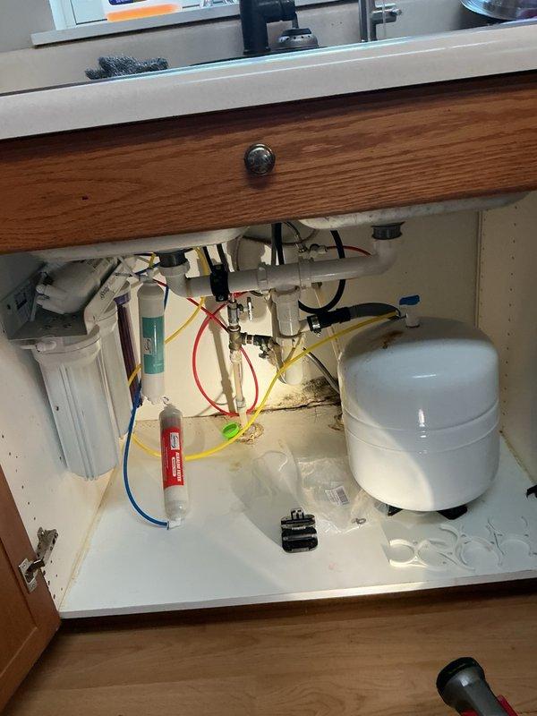 Responded to kitchen sink with no water flow following homeowner's faucet cord replacement, slow-filling toilet, and leaking reverse osmosis system. Upon inspection, determined check valve in kitchen faucet was installed backwards, preventing water flow. Corrected check valve orientation to restore proper water supply to sink. Diagnosed plugged fill valve in toilet causing slow tank refill. Removed and replaced defective fill valve with new unit to restore proper flush cycle. Removed leaking reverse osmosis system per homeowner request as unit was not in use. Tested all repairs to verify proper operation of kitchen faucet and toilet function.