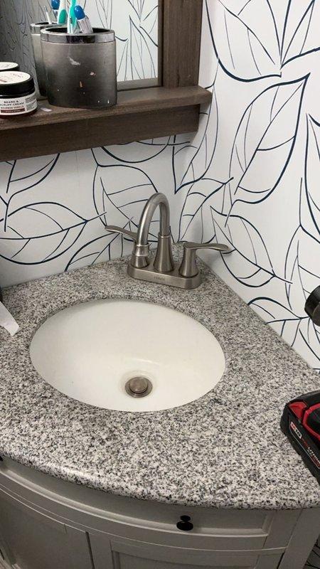 Completed comprehensive plumbing inspection of residential bathroom facilities. Inspected and documented bathroom vanity plumbing system including undermount sink with dual-handle brushed nickel faucet, drainage assembly, and supply line connections. Evaluated modern dual-flush toilet installation, verified proper operation of flush mechanism, and assessed all associated water supply and waste connections for leaks or potential issues.