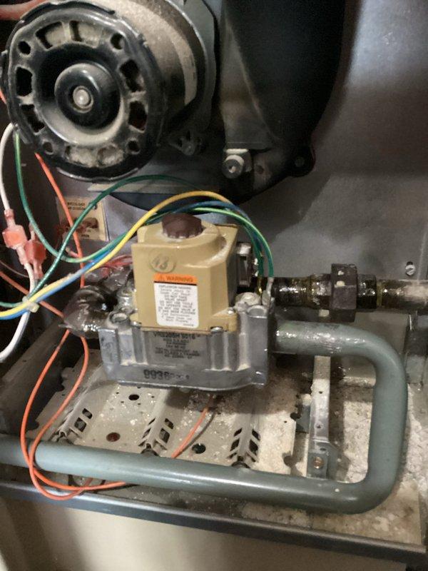 Responded to reported gas leak at 30-year-old furnace and water heater. Performed comprehensive leak detection using soap bubble test on furnace control valve, gas supply lines, and all fittings and connections. No active leaks detected at furnace gas valve assembly or supply piping during testing. 

Upon further inspection, discovered evidence of melting and heat damage at top of water heater, indicating potential backdrafting condition. This represents a safety hazard as combustion gases may not be properly venting, creating risk of carbon monoxide exposure and equipment damage. Documented findings with photographs showing furnace gas valve assembly, blower motor housing, and mechanical components in utility space.

Recommended replacement of aging furnace with high-efficiency unit featuring alternative venting configuration to eliminate backdrafting concerns and improve system safety. Coordinated with licensed plumber to evaluate water heater venting system, verify gas connections a