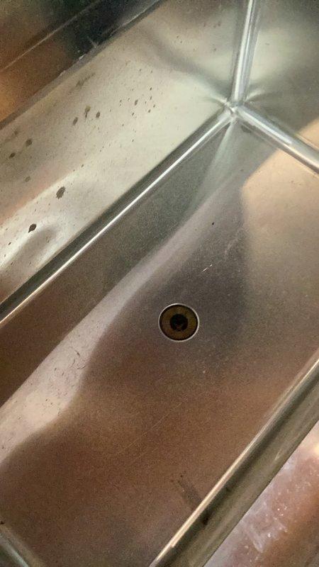 Completed installation and connection of commercial bar sink with drain assembly. Connected two separate drain lines to stainless steel basin, ensuring proper fit of brass drain fittings and verifying secure connections throughout the system. All plumbing connections tested and confirmed operational for commercial use.