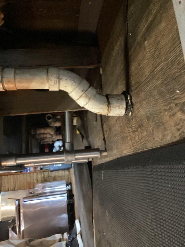 Completed installation and connection of commercial bar sink with drain assembly. Connected two separate drain lines to stainless steel basin, ensuring proper fit of brass drain fittings and verifying secure connections throughout the system. All plumbing connections tested and confirmed operational for commercial use.