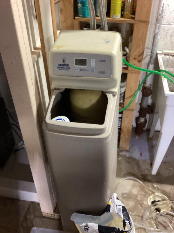 Responded to service call for Morton System Saver water softener experiencing continuous discharge and cycling malfunctions. Upon arrival, found unit displaying error code with brine tank half full and softener stuck in regeneration cycle, resulting in ongoing water waste. Diagnosed failed control valve assembly preventing proper cycle completion. Bypassed softener system to immediately stop water discharge and prevent further water loss. Documented equipment condition with photos showing unit installation, plumbing connections, and salt reservoir status. Recommended complete softener replacement due to control valve failure and age of unit.