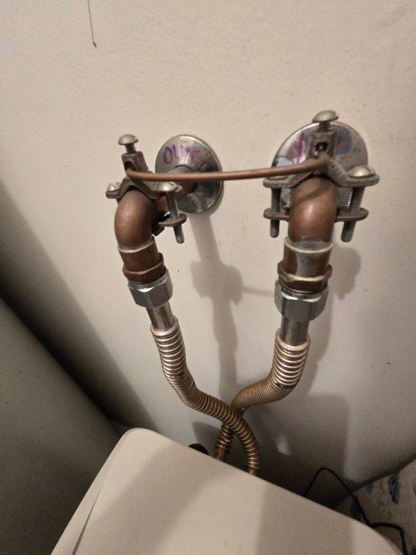 Conducted on-site evaluation of existing water softener system experiencing extended regeneration cycles of approximately 3 hours, indicating potential malfunction or component failure due to age. Assessed current plumbing configuration including wall-mounted supply line connections with braided metal hoses and copper fittings showing oxidation. Inspected mechanical room setup containing water heater and softener unit with dual supply lines. Documented equipment condition and provided bid estimate for water softener replacement to restore proper system operation and reduce excessive cycle times.