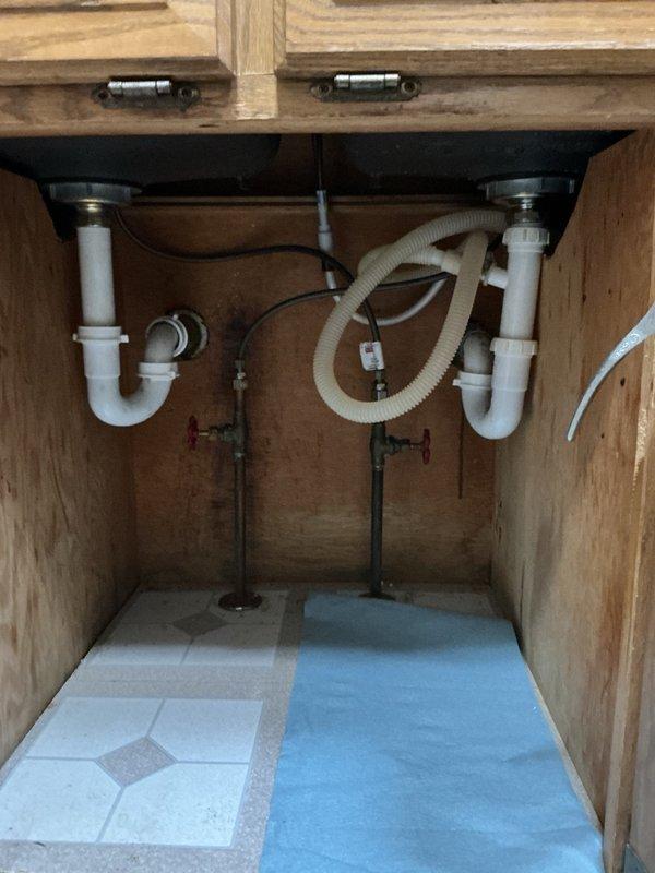 Responded to clogged kitchen sink with complete drainage backup. Upon inspection, determined blockage was caused by severe grease and hair accumulation in the drain line. Accessed plumbing beneath sink cabinet and deployed rigid drain snake machine to clear obstruction. Successfully restored full drainage function to kitchen sink. Verified proper water flow through P-trap assemblies and drain lines upon completion.