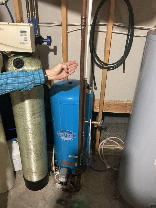Responded to complaint of air in water lines on well system. Performed diagnostic inspection of pressure tank, water softener, and associated plumbing connections. Identified air entrainment most likely originating from Culligan water softener brine tank malfunction. Pressure tank and well system components found to be functioning within normal parameters. Recommended repiping to address chronic air infiltration issues and advised customer to contact Culligan for service on water treatment system to resolve brine tank problem causing air introduction into water supply lines.