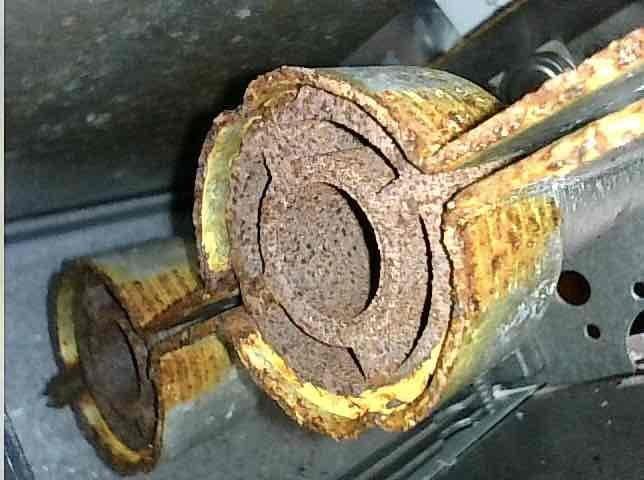 Performed furnace tune-up on system less than one year old and discovered severely corroded burner assembly that failed to ignite on first attempt due to excessive condensation intrusion from intake pipe drain kit. Relocated drain kit approximately one foot above burner box to prevent further moisture infiltration into the unit. Submitted parts order for replacement burner assembly under manufacturer warranty and documented extensive rust damage with photographs.