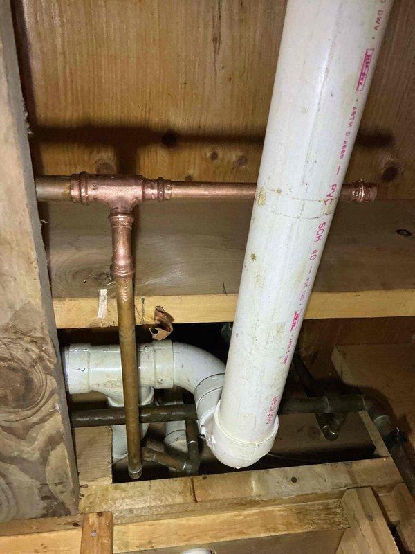 Responded to emergency water leak caused by laundry tub detaching from wall, resulting in broken supply pipes near the main water valve. Disconnected damaged laundry tub connections and restored main house water supply by reconnecting and securing copper piping infrastructure. Customer also reported natural gas water heater not heating properly; preliminarily assessed heating element as likely cause of malfunction in 8+ year old unit requiring further evaluation or replacement.