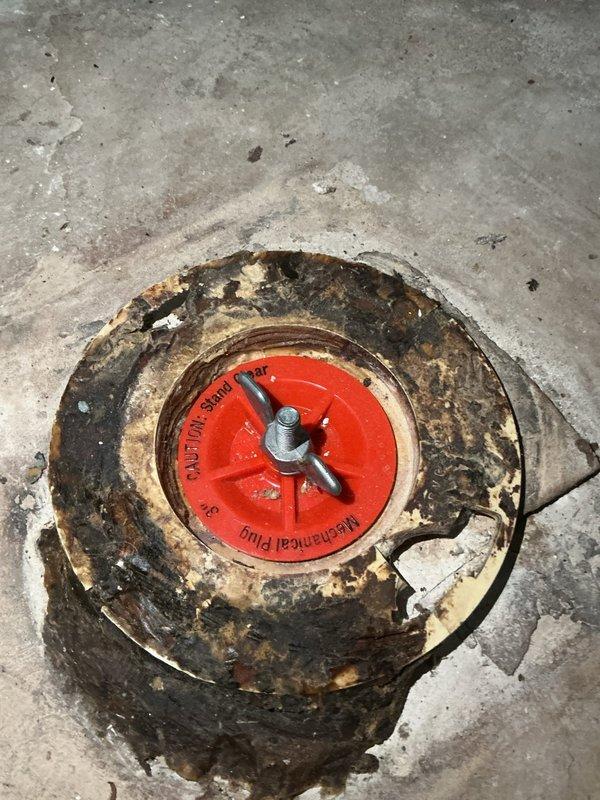 Returned to complete basement toilet installation after fixture became available. Repaired corroded and damaged toilet flange in concrete floor. Installed new water supply line by teeing off existing plumbing, including shut-off valve and supply line connection. Successfully set and secured toilet to restored flange.