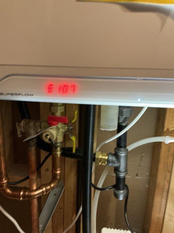 Responded to no hot water complaint on tankless water heater system. Upon inspection, diagnosed faulty control board causing unit malfunction and displaying error code E187. Removed defective circuit board and installed replacement board from inventory. System fired up immediately upon installation and restored full hot water functionality. Verified all electrical connections, tested unit operation, and confirmed proper heating performance. Completed part order documentation to replenish shop inventory with replacement control board.