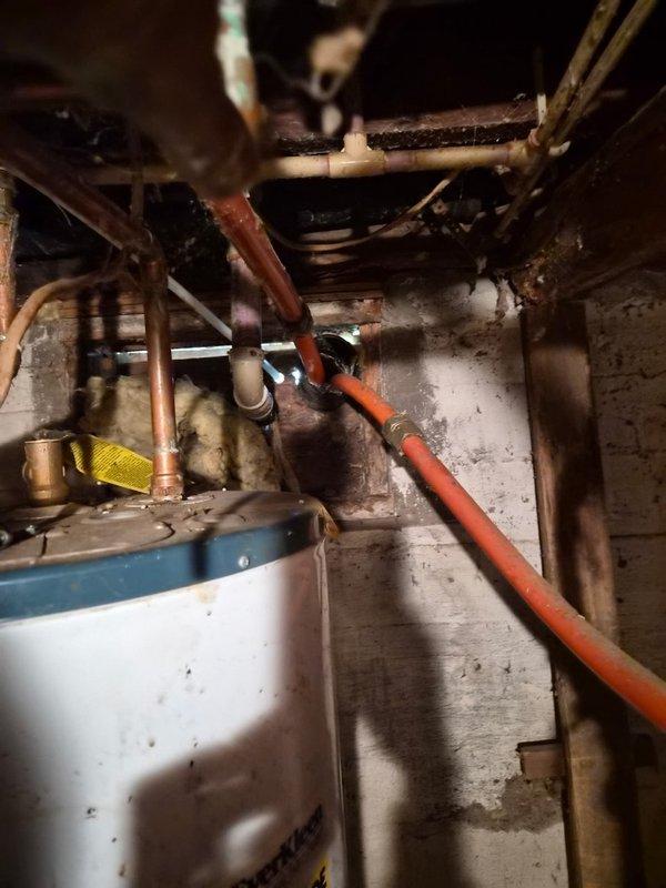 Disconnected and removed outdoor woodstove piping that had been previously connected to the LP gas furnace by the prior homeowner. Cut and capped the piping inside the mechanical room to safely isolate the woodstove from the gas furnace system, with the homeowner responsible for removing the external components. Documented the work with photos showing the furnace, ductwork, and disconnected piping configuration.