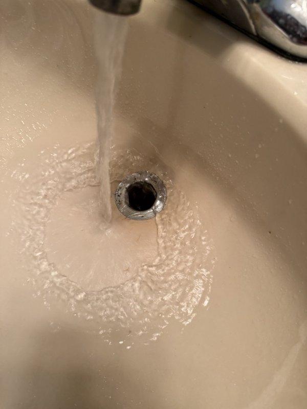 Completed plumbing inspection to assess water leak concerns and evaluate existing plumbing fixtures. Examined sink faucet operation and drainage system, noting active water flow and proper drain function. Inspected bathtub/shower valve assembly and identified mineral buildup on handle and escutcheon plate, along with hard water deposits on shower arm components indicating age-related wear. Documented fixture conditions with photographs and prepared estimates for recommended repairs and potential fixture replacement based on undetermined age of existing plumbing system.
