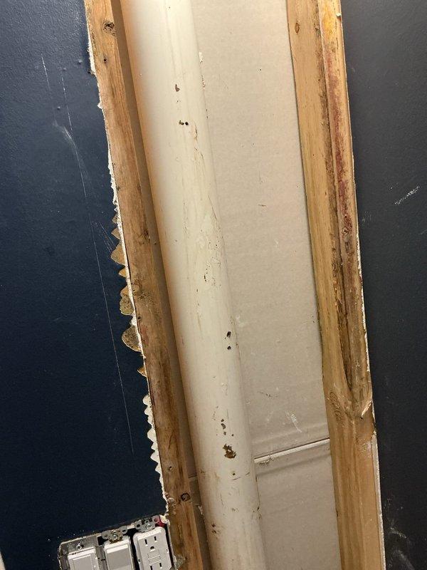 Responded to water leak emergency as a return visit following initial assessment by restoration company. Located multiple punctures in the plumbing stack that were causing active water intrusion into the structure. Upon inspection, discovered significant rodent damage to wooden framing and door trim adjacent to the plumbing penetration, with characteristic gnaw marks visible along exposed edges. Repaired all punctures in the vertical waste stack using appropriate patching methods to restore water-tight integrity. Tested the repaired line for leaks and verified proper function. Documented existing structural damage from rodent activity for property owner's awareness, including compromised wood studs and trim surrounding the plumbing chase. The plumbing system has been fully restored to proper working condition.