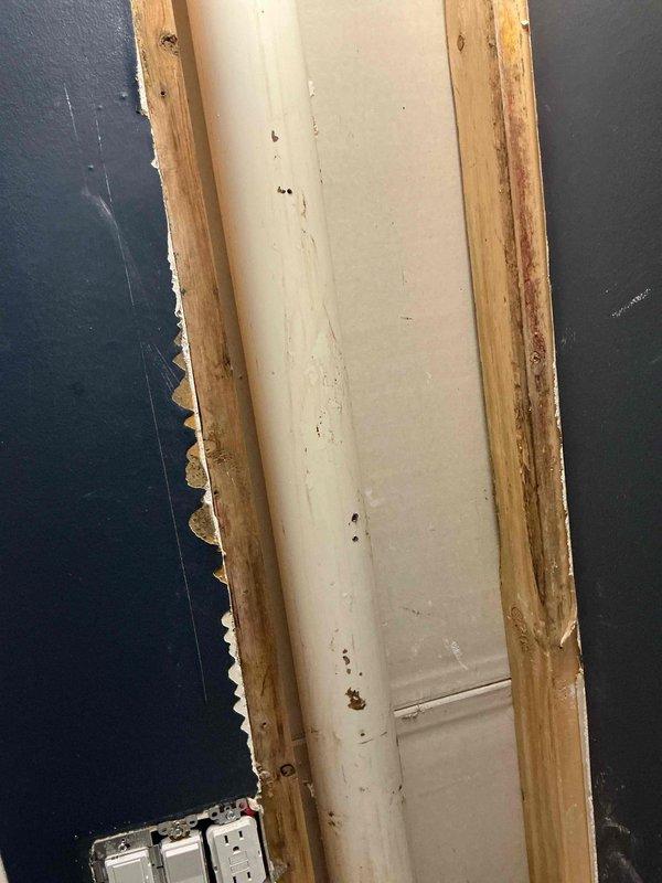 Responded to water leak emergency as a return visit following initial assessment by restoration company. Located multiple punctures in the plumbing stack that were causing active water intrusion into the structure. Upon inspection, discovered significant rodent damage to wooden framing and door trim adjacent to the plumbing penetration, with characteristic gnaw marks visible along exposed edges. Repaired all punctures in the vertical waste stack using appropriate patching methods to restore water-tight integrity. Tested the repaired line for leaks and verified proper function. Documented existing structural damage from rodent activity for property owner's awareness, including compromised wood studs and trim surrounding the plumbing chase. The plumbing system has been fully restored to proper working condition.