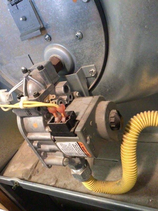 Responded to no heat call on wall-mounted furnace unit. Upon inspection, found furnace failing to ignite. Performed diagnostic testing and confirmed 24 volts present at gas valve, indicating proper electrical signal. Measured incoming gas pressure at 10" water column to the valve, which was within normal range. However, discovered no gas flow through the valve when energized, indicating a failed gas valve preventing fuel delivery to the burners. Documented equipment with photos showing the wall-mounted unit installation and the gas valve assembly with connected yellow flex line and wiring. Determined gas valve requires replacement to restore heating operation.