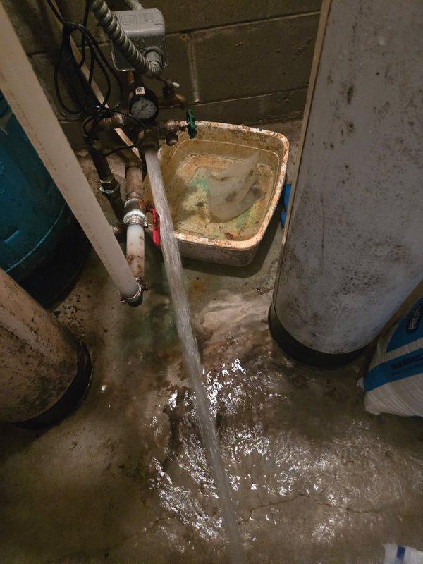 # Emergency Water Leak Repair - Well Tank System

Responded to emergency call for active water leak in basement utility area. Upon arrival, found significant flooding with water accumulation across concrete floor. Customer was unable to identify leak source or water shut-off location.

## Problem Identified

Conducted thorough inspection of plumbing system and identified failed adapter connection on Well-Rite pressure tank (Tank T). The broken adapter was causing uncontrolled water discharge, resulting in basement flooding with water levels reaching several inches deep.

## Work Performed

- Located and shut off water supply to isolate affected system
- Assessed extent of flooding and leak damage to utility room
- Removed failed adapter component from pressure tank
- Installed new replacement adapter on Tank T
- Reconnected all associated copper piping and fittings to pressure tank system
- Restored water supply and tested system for proper operation
- Verified all connections were sec