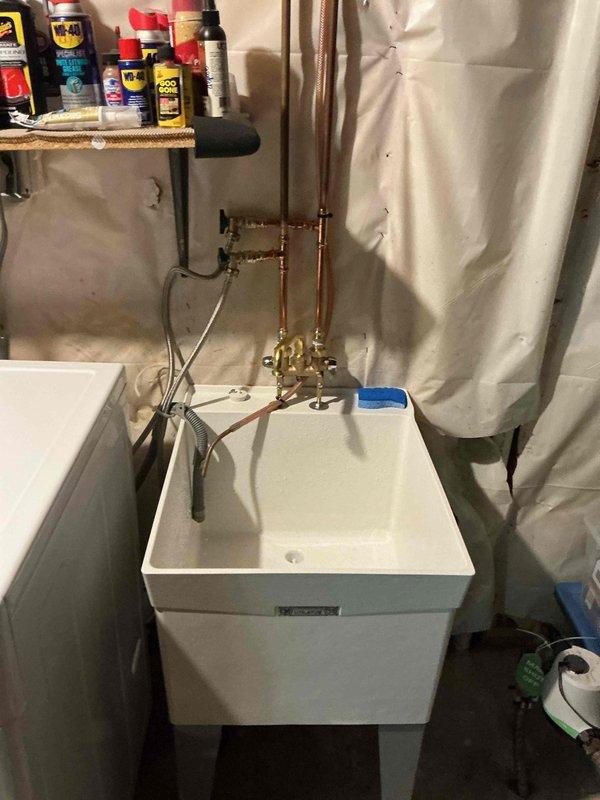 Completed installation of new laundry utility sink with brass top-mount faucet and washer stops in mechanical room. Installed three 3/4" ball valves on copper supply lines to provide shutoff capability for the plumbing system. All fixtures and valves were properly secured and tested for proper operation and leak-free connections.