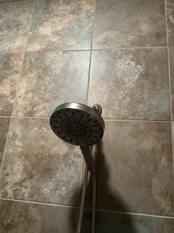Responded to callback for persistent low shower pressure issue. Upon inspection, identified additional debris lodged in handheld shower head nozzles that was restricting water flow. Thoroughly cleaned and flushed shower head assembly, removing all obstructions to restore proper water pressure and spray pattern.