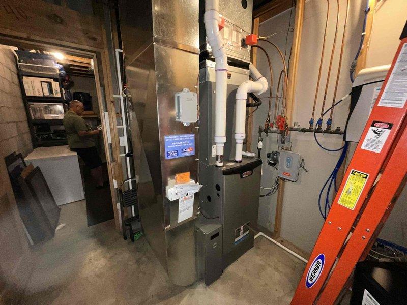 Conducted on-site assessment for replacement of existing water heater with new 75-gallon residential unit. Evaluated current basement utility room configuration, including existing water heater connections, copper and PVC supply lines, drainage systems, and available clearances for installation. Documented existing plumbing infrastructure, overhead piping arrangements, and proximity to HVAC equipment to ensure proper spacing and code compliance for new unit installation. Photographed current setup showing water heater positioning, pipe connections, electrical requirements, and access points for removal and replacement work.